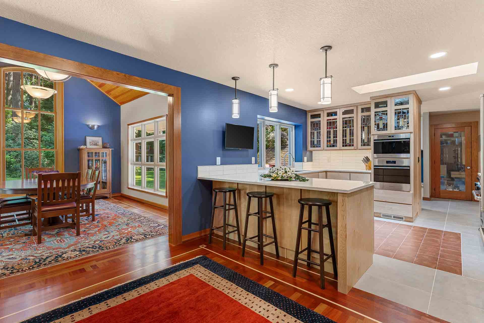 Kitchen remodel with warm tones and breakfast bar by Creekstone Design + Remodel