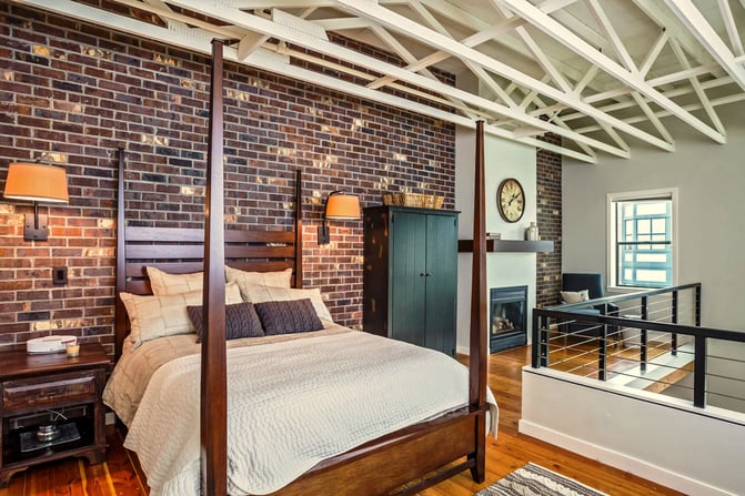 Transitional-Loft-Finished-Brick-Walls-Hardwood-Floors-Framed-in-Gas-Fireplace-Sconse-Bed-Lighting