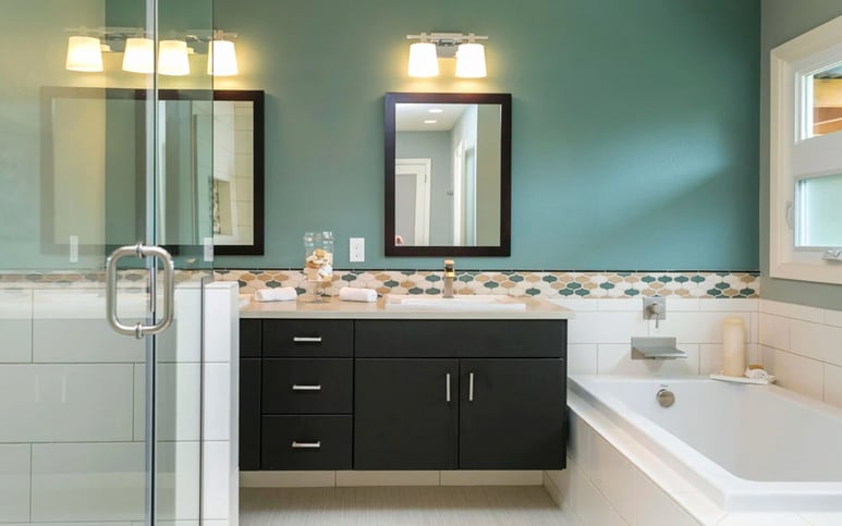 Remodeled bathroom with teal wall and white tile by Creekstone Design + Remodel