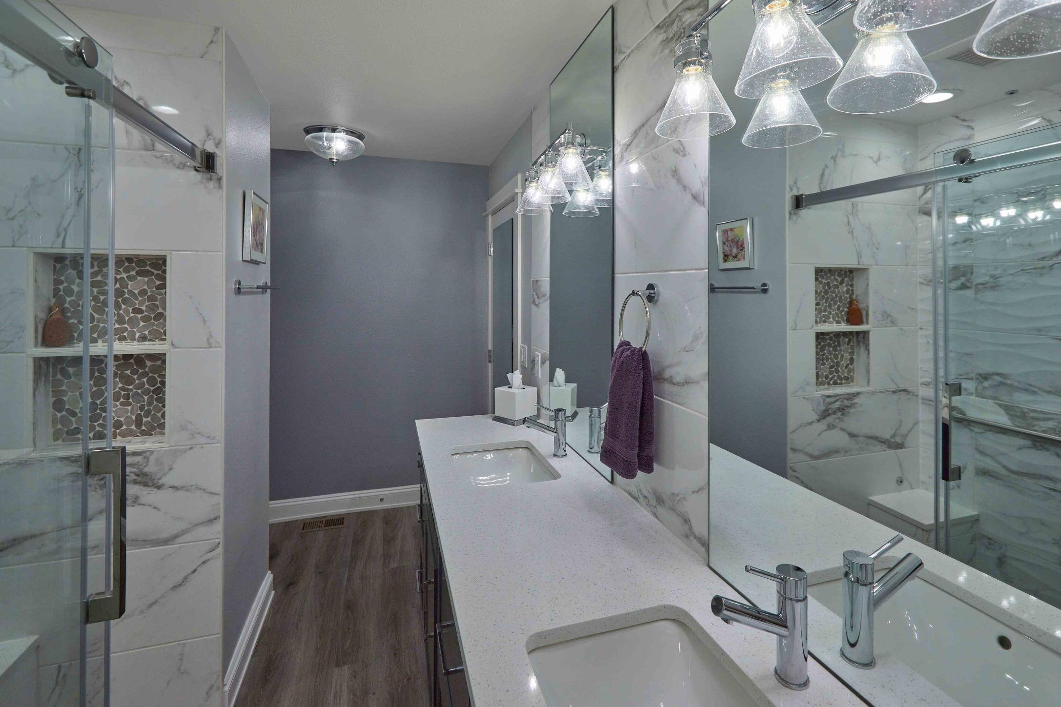 Remodeled basement full-bathroom with jack and jill sinks, and walk-in shower in Tigard, OR by Creekstone Design + Remodel