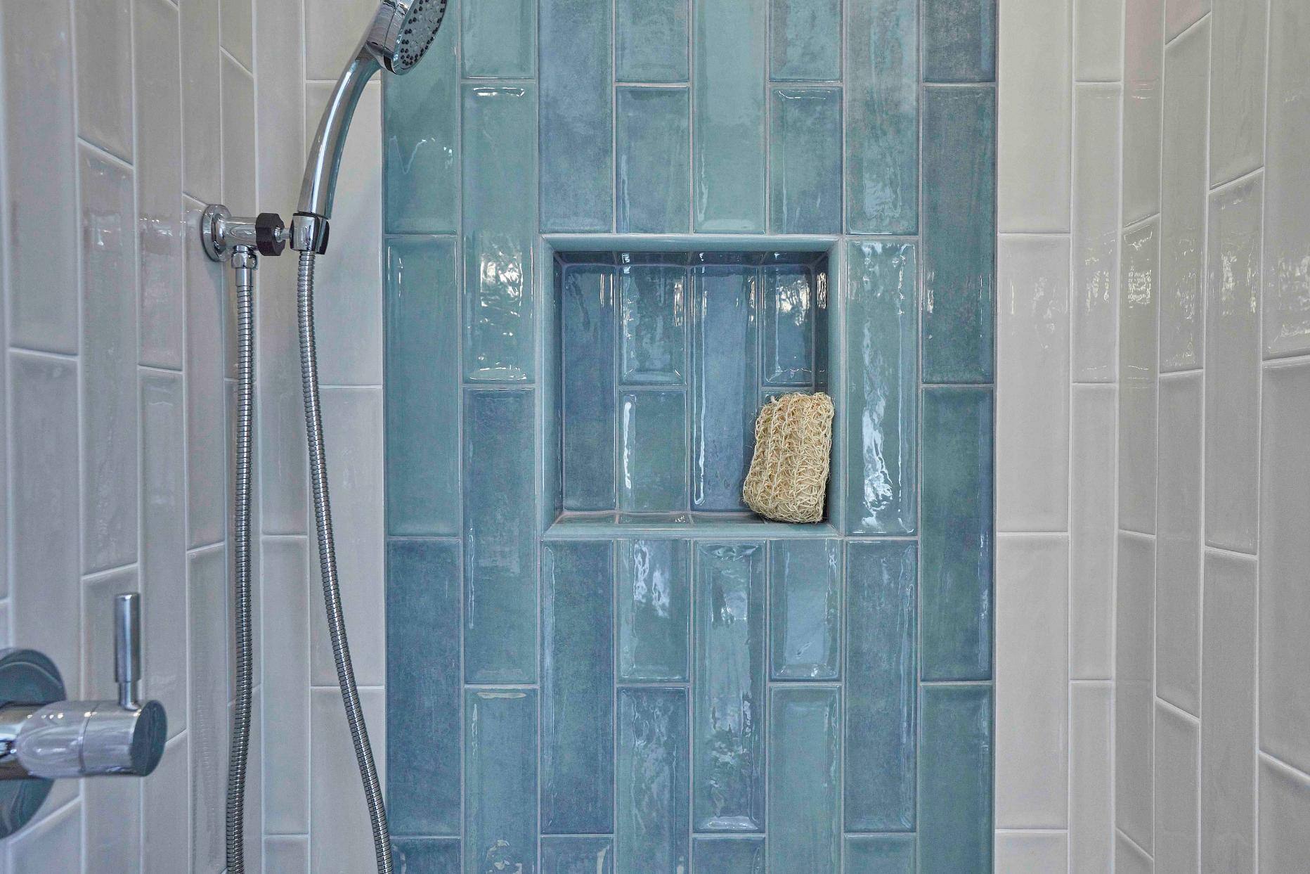 Remodeled bathroom shower with blue and white tile in Tigard, OR by Creekstone Design + Remodel