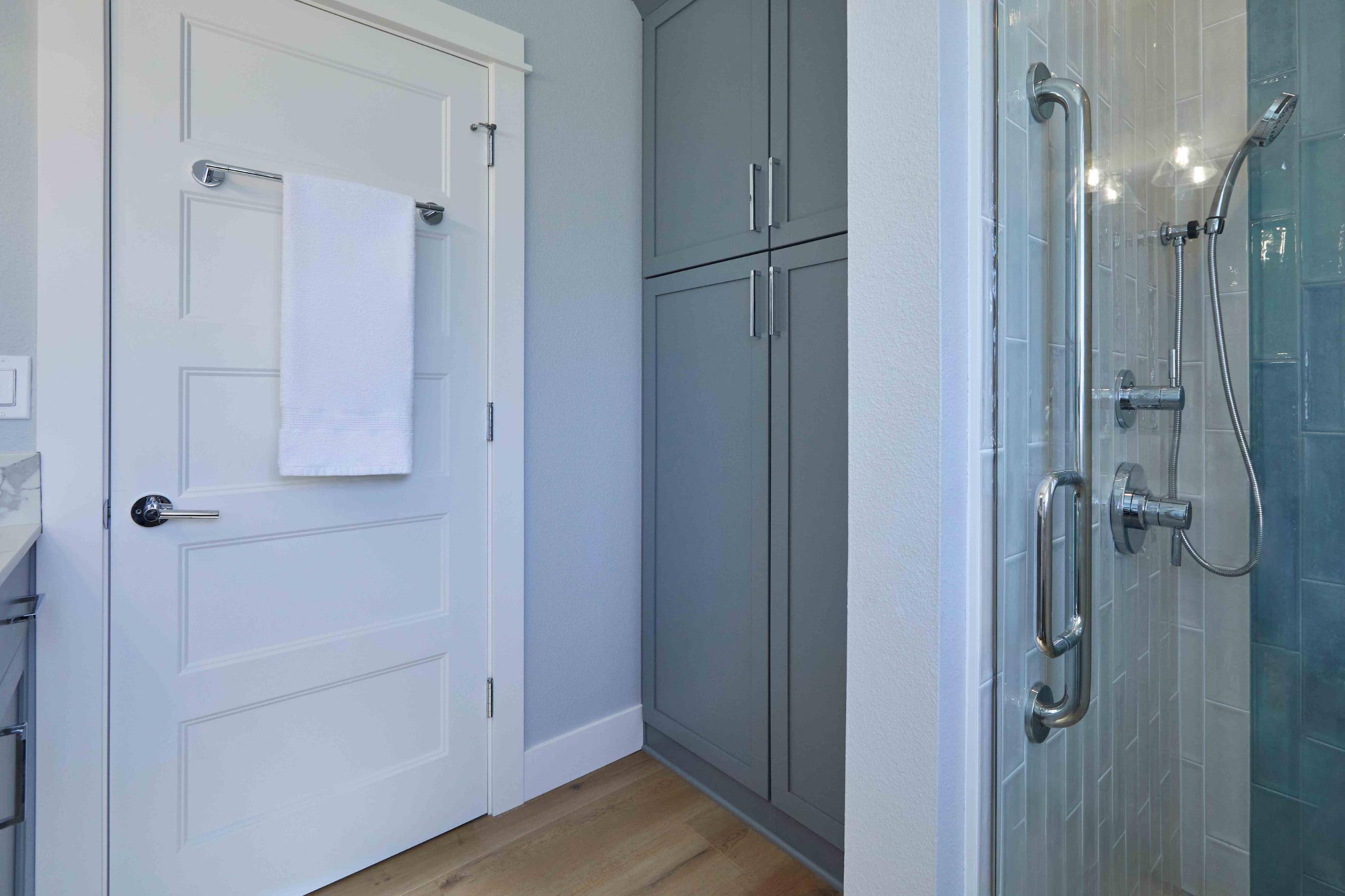 Remodeled bathroom with storage closet and walk-in shower in Tigard, OR by Creekstone Design + Remodel